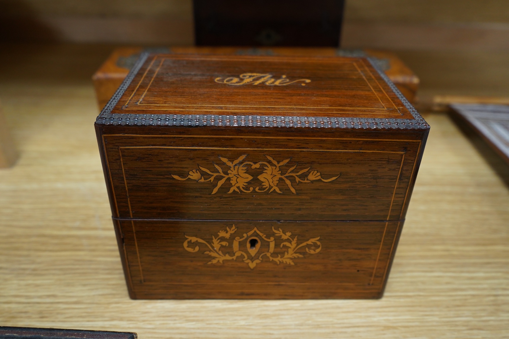 Four boxes to include a burr elm bound example, together with a French inlaid ‘Thé’ caddy with porcelain canisters, largest 32cm wide